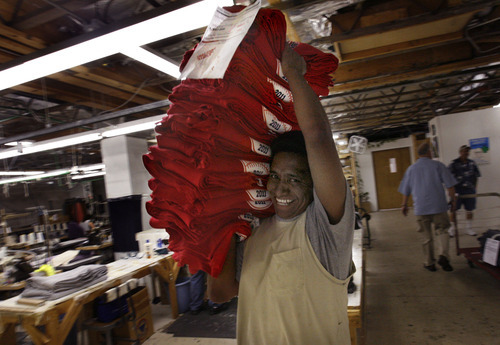 Scott Sommerdorf  |  The Salt Lake Tribune
Cesario Bartolo takes a finished order of shirts away from the sewing floor at SanSegal Sportswear in Sandy, Thursday, July 21, 2011. SanSegal Sportswear manufactures a 