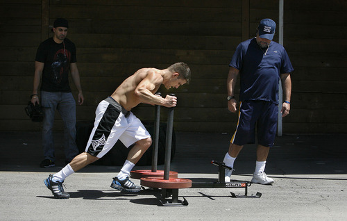 Scott Sommerdorf  |  The Salt Lake Tribune
Mixed Martial Arts fighter Rad Martinez of West Jordan pushes a weighted sled 40 yards across the parking lot fifteen times as part of his MMA training session at the Riven Academy in Orem, Thursday, August 11, 2011.