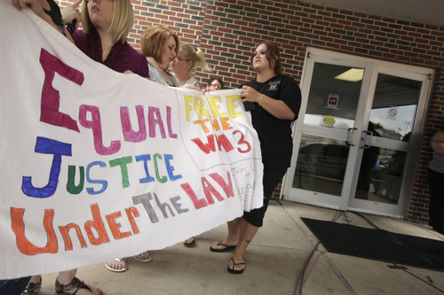 Women hold a sign at the Craighead County Court House in Jonesboro, Ark., Friday, Aug. 19, 2011, proclaiming innocence of three Arkansas men convicted in the 1993 deaths of three West Memphis, Ark., children. The three men convicted of the killings are at a hearing Friday that could end with their release from custody after nearly two decades in prison. (AP Photo/Danny Johnston)