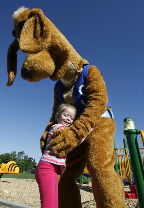 Francisco Kjolseth  |  The Salt Lake Tribune
Slyde the Playground Hound gives hugs to students at the Jean Massieu School of the Deaf during a celebration of the unveiling of a new playground. Last week, vandals painted the playground with blue graffiti, but community volunteers cleaned up the $155,000 playground before the unveiling on Monday, August 22, 2011. Kids at the school pitched in $55,000 through fundraising to make it all happen.