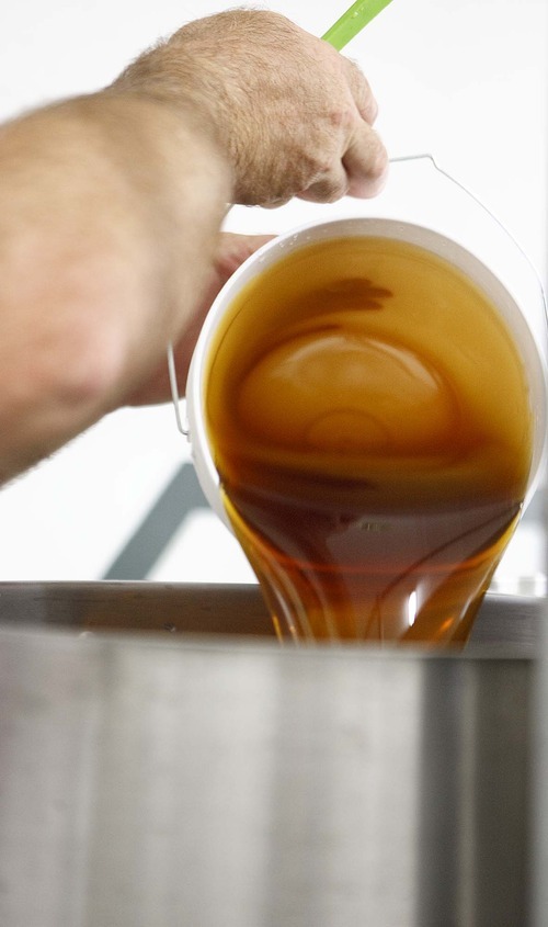 Trent Nelson  |  The Salt Lake Tribune
Honey is poured into a bucket at the Slide Ridge farm in Mendon, Utah. Martin James and his family produce a unique Honey Wine Vinegar made from raw honey (from their own hives) and fermented in special process. Similar to balsamic vinegar it can be used as a glaze for meat or drizzled on everything from a salad to ice cream. The honey wine vinegar is getting lots of praise from local experts, who say it's one of the best food products being made in Utah.
Tuesday, August 16, 2011.