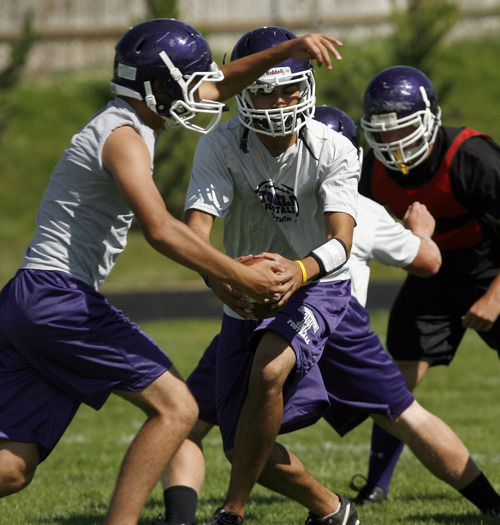 Francisco Kjolseth  |  The Salt Lake Tribune
Quarterback Alvaro Fernandez of Tooele High hands off during a recent practice. Coach Kyle Brady, a Tooele High School alum and former University of Utah linebacker, has been working with his team in his first year as the head coach of his alma mater in Tooele.