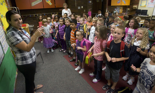 Al Hartmann  |  The Salt Lake Tribune
First-graders at Horizon Elementary School in Murray sing their first song in Spanish with their Spanish speaking teacher Karina Guzman on the first day of school Monday August 22.  The class is dual immersion.     They spend the other half of their classroom experience with English speaking teacher Linda Curtis in back and center of photo.
