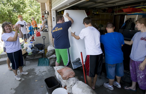 Tribune file photo by Al Hartmann
Neighbors pitched in to move a refrigerator from the swamped garage of Murray residents Cheryl and Joel Leithead, who have filed a claim seeking compensation from a $165,000 fund set up by Salt Lake County.