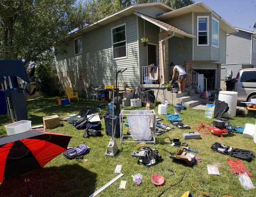 Tribune file photo by Al Hartmann
Cheryl and Joel Leithead spread soaked possessions out on their front lawn to dry after a July 26 thunderstorm overwhelmed an out-of-commission storm drain and flooded their Murray home. The Salt Lake County council has approved $165,000 to help reimburse homeowners for their losses.