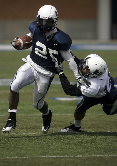 Francisco Kjolseth  |  The Salt Lake Tribune
Kerwynn Williams, left, gets the pull from Jamaine Olson as Utah State has their Spring football game on Saturday, April 23, 2011, at Romney Stadium in Logan in front of the Aggie fans.