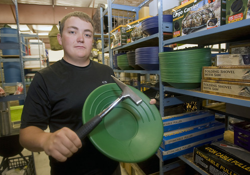 Al Hartmann  |  The Salt Lake Tribune
General Army Navy Outdoor store employee Tavey Sullivan stacks shelves with gold pans. The Taylorsville store, which sells surplus merchandise and other items, has been experiencing a run of sorts on its gold pans and rock picks.