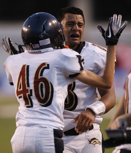 Trent Nelson  |  The Salt Lake Tribune
Herriman quarterback Tueni Lupeamanu is overcome with emotion after the overtime win. Teammate Logan Spackman at left. Herriman vs. Riverton High School football at Rice-Eccles Stadium in Salt Lake City, Utah, Saturday, August 27, 2011.