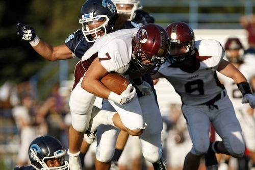 Chris Detrick  |  The Salt Lake Tribune
Jordan's Taylor Loomis (7) is tackled by Layton's Daviaire Dickerson (24) during the game at Layton High School Friday August 26, 2011.