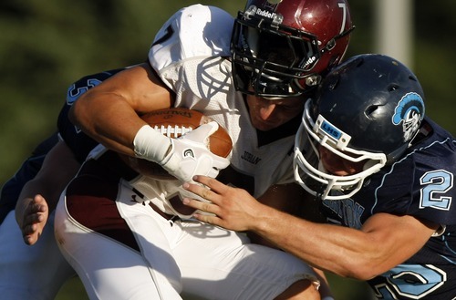 Chris Detrick  |  The Salt Lake Tribune
Jordan's Taylor Loomis (7) is tackled by Layton's Devon Nippert (28) and Jamison Walker (37) during the game at Layton High School Friday August 26, 2011.