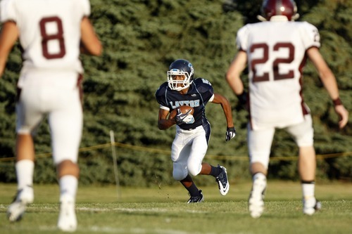 Chris Detrick  |  The Salt Lake Tribune
Layton's Tyler Fox (5) runs the ball while being defended by Jordan's Tyler Swan (8) and Jordan's Timmy Watson (22) during the game at Layton High School Friday August 26, 2011.