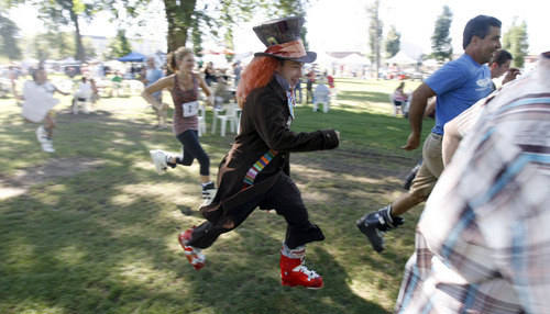 Francisco Kjolseth  |  The Salt Lake Tribune
Jeff Taylor wearing a Mad Hatter costume tries his luck for the first ever Yeti Pass Skootch'n Dash at the Downtown Farmer's Market on Saturday, September 3, 2011. Costume-clad competitors raced in one of two hilarious athletic events - a ski boot run (approximately 1K) or a 50-meter snowboard skootch.