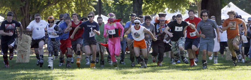 Francisco Kjolseth  |  The Salt Lake Tribune
Ski boot wearing runners participating in the first ever Yeti Pass Skootch'n Dash  at the Downtown Farmer's on Saturday, September 3, 2011. Costume-clad competitors raced in two hilarious athletic events - a ski boot run (approximately 1K) or a 50-meter snowboard skootch. The fastest racers in each division won prizes including Rossignol skis or snowboard, Smith Optics and other Ski Utah swag. A special award for the best costume, as judged by a panel, won a Ski Utah Yeti Pass good for one day of skiing at every Utah resort during the 2011-12 season. The registration fee to participate was five-dollars per person per race and 50 percent of profits earned will be donated to the Utah Avalanche Center.