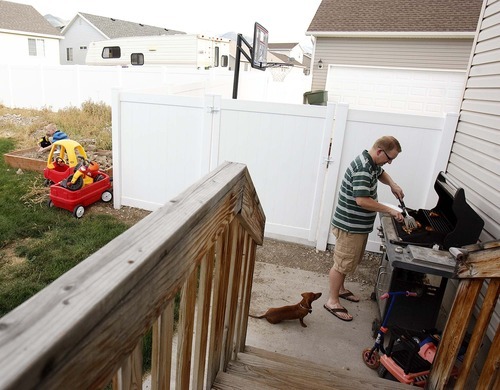 Trent Nelson  |  The Salt Lake Tribune
Scott Burton grills dinner as Lucy, the family dog, watches, Aug. 25. The Burtons are trying to sell their home in Tooele because of a job transfer. Despite adding more than $20,000 in improvements since they purchased the home in 2005, the Burtons are now asking only what they paid for the home.