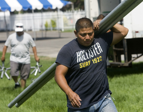 Al Hartmann  |  The Salt Lake Tribune
Carlos Michelen with Diamond Rental hoists poles to erect one of the many tents going up at the Utah State Fairpark on Aug. 30.  Carnival rides are being set up, tents raised, and vendor booths are getting prepared for the opening of the Utah State Fair on Sept. 8.