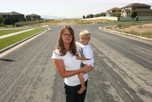 Leah Hogsten  |  The Salt Lake Tribune
 Christine Peck holding son Alex, 2,  Thursday, September 8 2011 in Farmington lives near the proposed corridor route that would run through 950 North in Farmington where she is standing and take out the 12 houses in the neighborhood behind her to the right. Several months ago she organized a 