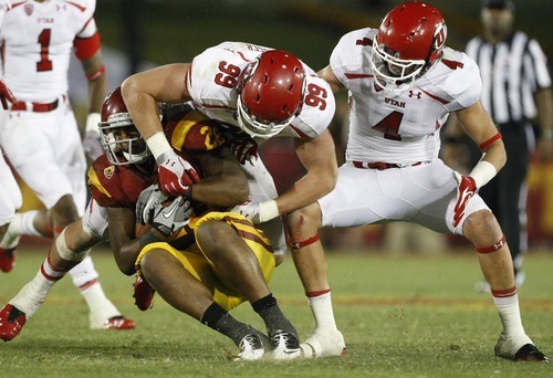 Chris Detrick  |  The Salt Lake Tribune
Utah Utes defensive end Joe Kruger (99) tackles USC Trojans running back Marc Tyler (26) during the fourth quarter of the game at the Los Angeles Memorial Coliseum Saturday September 10, 2011.