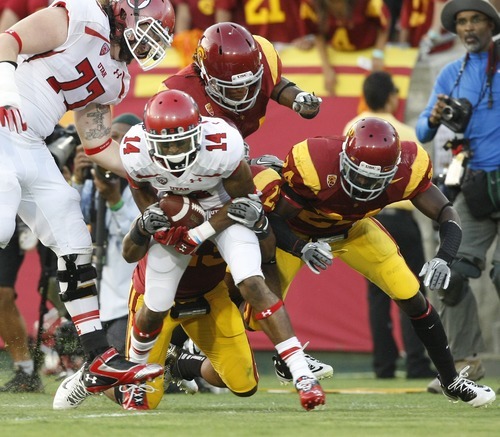 Chris Detrick  |  The Salt Lake Tribune
Utah Utes wide receiver Reggie Dunn (14) is tackled by USC Trojans safety Tony Burnett (34) USC Trojans linebacker Shane Horton (23) and USC Trojans safety Demetrius Wright (24) during the second half of the game at the Los Angeles Memorial Coliseum Saturday September 10, 2011.