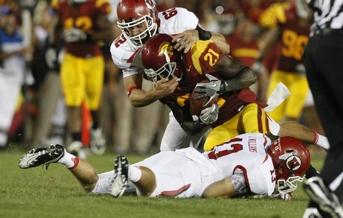 Chris Detrick  |  The Salt Lake Tribune
Utah Utes long snapper Patrick Greene (62) and Utah Utes linebacker J.J. Williams (13) tackle USC Trojans wide receiver Kyle Prater (21) during the second half of the game at the Los Angeles Memorial Coliseum Saturday September 10, 2011.