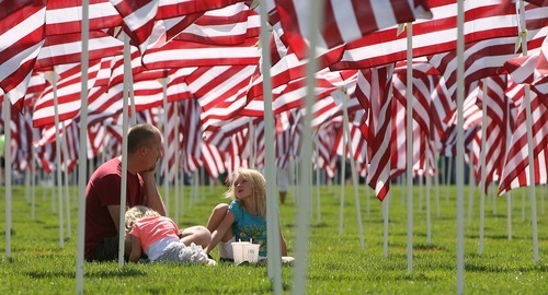 Leah Hogsten  |  The Salt Lake Tribune
Greg Irvine of Sandy and his daughters Kiana, 8, in blue and Kaylee,4, take a break in the Utah Healing Field after the ceremony. Irvine's brother is a pilot in the Navy. Thousands attended Sandy city's Utah Healing Field 9/11 Memorial on the grounds of City Hall to watch the Hope Rising 9/11 bronze monument unveiling  of three NYC firefighters Saturday, September 10 2011 in Sandy . The 2011 Fire Ride for motorcyclists commemorated the tenth anniversary of the World Trade Center attacks.