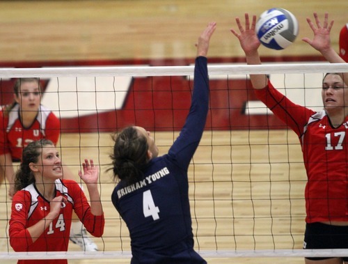 Rick Egan  | The Salt Lake Tribune 

Kathryn LeCheminant knocks the ball over the net, as Abby Simmons,14, and Erin Redd, 17,  defend for the Lady Utes, in volleyball action, Utah vs. BYU, in Salt Lake City, Saturday, September 10, 2011.