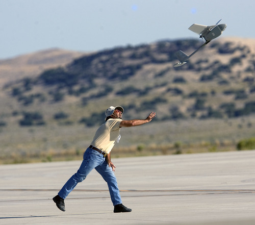 Al Hartmann  |  The Salt Lake Tribune
Aircraft of the Manned-Unmanned System Integration Capability (MUSIC) was demonstrated at Dugway Proving Grounds on Thursday, Sept. 15.   Michael Reagan of AeraVironment launches a Raven, a small surveillance plane used in the demonstration.
