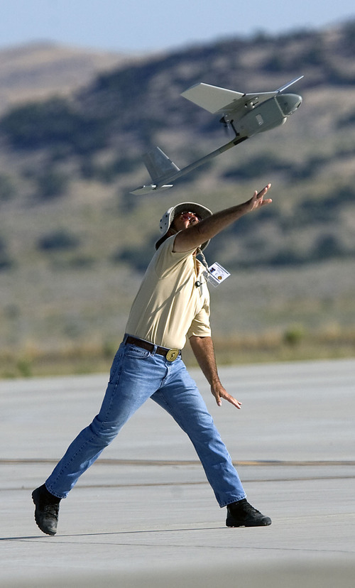 Al Hartmann  |  The Salt Lake Tribune
Aircraft of the Unmanned System Integration Capability (MUSIC) was demonstrated at Dugway Proving Grounds on Thursday, Sept. 15.   Michael Reagan of AeraVironment launches a Raven, a small surveillance plane used in the demonstration.