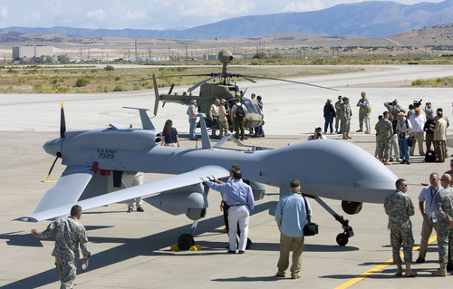 Al Hartmann  |  The Salt Lake Tribune
Aircraft of the Manned-Unmanned System Integration Capability (MUSIC) was demonstrated Thursday at Dugway Proving Ground.  Crowds of contract workers and Dugway personnel get a close look at a MQ-1C Gray Eagle in foreground and a Kiowa helicopter behind it after the demonstration.