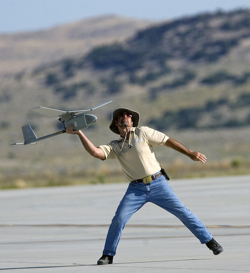 Al Hartmann  |  The Salt Lake Tribune
Aircraft of the Manned-Unmanned System Integration Capability (MUSIC) was demonstrated at Dugway Proving Grounds on Thursday. Michael Reagan of AeraVironment launches by hand a Raven, a small surveillance plane used in the demonstration.