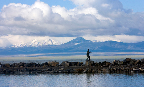 Al Hartmann  |  The Salt Lake Tribune   4/13/2010&#xA;Fisherman picks his way along the bolder jetty on Utah Lake State Park west of Provo to try his luck inbetween storms.  The early morning storm was moving out and breaking up creating a pallete of unusual colors and clouds over the lake.