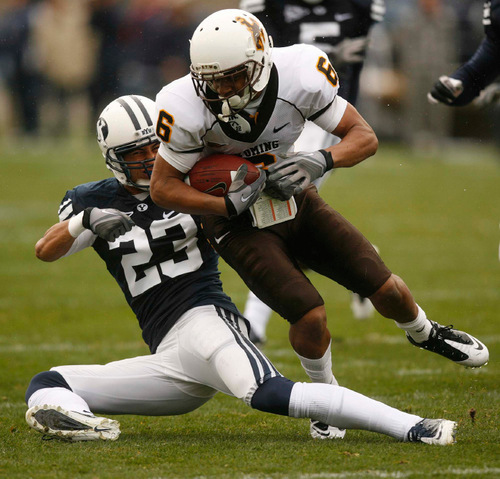 Trent Nelson  |  The Salt Lake Tribune
BYU defensive back Travis Uale (23) pulls down Wyoming's Robert Herron during the first half, BYU vs. Wyoming, college football Saturday, October 23, 2010 at LaVell Edwards Stadium in Provo.