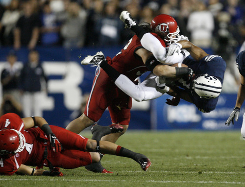 Trent Nelson | The Salt Lake Tribune

BYU wide receiver Ross Apo (11) is tackled by Utes linebacker Chaz Walker (32) and Utes linebacker Brian Blechen (4) (left) during BYU's game against Utah at Lavell Edwards Stadium in Provo, Utah September 17, 2011.