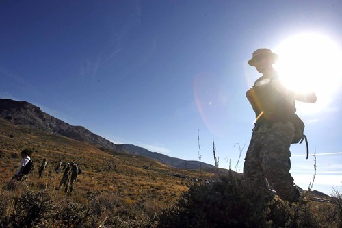 Rick Egan  | The Salt Lake Tribune 

Rescue workers form a walk line as they comb the Topaz mountain area, near highway 174, early Monday morning, September 19, 2011.