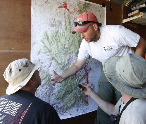 Rick Egan  | The Salt Lake Tribune 

West Valley City rescue workers review the map of the Topaz Mountain area, early Monday morning, September 19, 2011.