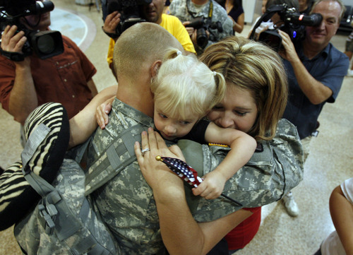 Francisco Kjolseth  |  The Salt Lake Tribune
Specialist Monan Brennan of Layton gets a large family hug from his daughter, Melody, 2, and fiancé Chelsea Wells as he arrives with the first wave of approximately 40 soldiers from the 971st Medical Logistics Company (Army Reserve) in Ogden returning from deployment to Afghanistan on Wednesday, Sept. 21, 2011, at Salt Lake City International Airport. The 971st Medical Company's one-year mission was mostly the shipping and receiving of medical supplies.