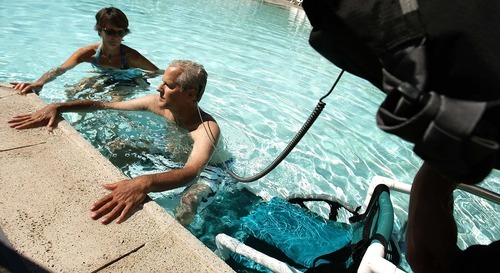 Leah Hogsten | The Salt Lake Tribune
Utahn Bill Boren swims with the help of a nurse, who carries Boren's LVAD battery pack, and physical therapist Lisa Carter (left). Boren, the first recipient of a waterproof artificial heart in North America, and Craig Selzman, surgical director of University of Utah's heart transplant program, demonstrated the device when Boren swam  Thursday, September 22 2011 at the IJ and Jeanne Wagner Jewish Community Center. Boren, 54, has muscular dystrophy and swimming is part of his therapy.