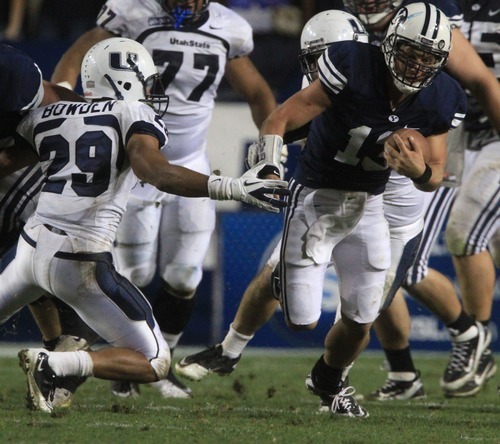 Rick Egan  | The Salt Lake Tribune 

 Brigham Young Cougars quarterback Riley Nelson (13) runs past Utah State Aggies safety Alfred Bowden (29) on a quarterback keeper, as BYU defeated Utah State, 27-24 in Provo, Friday, September 30, 2011.