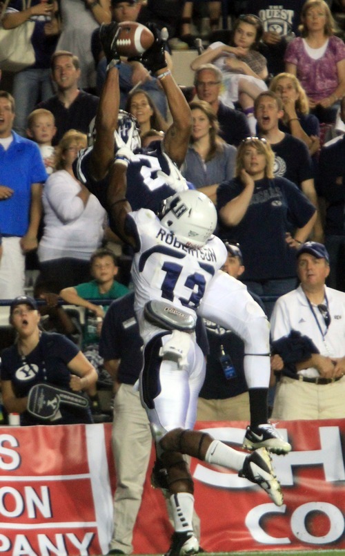 Rick Egan  | The Salt Lake Tribune 

Utah State Aggies cornerback Jumanne Robertson (13) hits Brigham Young Cougars wide receiver Cody Hoffman, but Hoffman holds onto the ball for a BYU Touchdown, in football action, BYU vs. Utah State, in Provo, Friday, September 30, 2011.