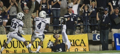 Rick Egan  | The Salt Lake Tribune 

 Brigham Young Cougars wide receiver Cody Hoffman,  holds onto the ball for a BYU Touchdown, in football action, BYU vs. Utah State, in Provo, Friday, September 30, 2011.  Utah State Aggies cornerback Jumanne Robertson (13)   Aggies safety Walter McClenton (4) are on the right.
