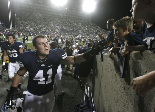 Rick Egan  | The Salt Lake Tribune 

Brigham Young Cougars running back Austin Heder (41) high-fives kids as he runs to the locker room after the Cougars last second victory over the Aggies, at Lavell Edwards Stadium in Provo, Friday, September 30, 2011.