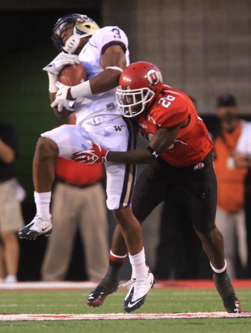 Rick Egan  | The Salt Lake Tribune 

Ute defensive back Ryan Lacy (26) hits Washington Huskies wide receiver James Johnson (3) as he catches the ball, in Pac-12 action, Utah vs. University of Washington, at Rice-Eccles stadium, Saturday, October 1, 2011.