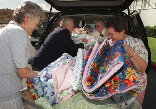 Besides attending church, Mormons also perform humanitarian outreach. Here, service missionaries unload donated quilts, which will be sent to Kosovo refugees.
