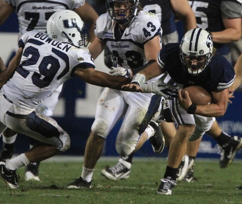 Rick Egan  | The Salt Lake Tribune 

 Brigham Young Cougars quarterback Riley Nelson (13) runs the ball on a quarterback keeper, as BYU defeated Utah State, 27-24 in Provo, Friday, September 30, 2011.