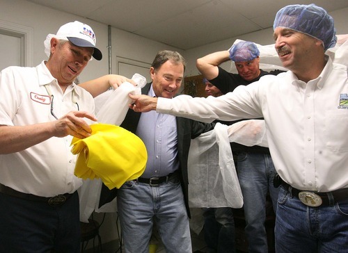 Leah Hogsten | The Salt Lake Tribune
l-r Dairy Farmers of America  Beaver plant manager Craig Willden hands out shoe covers to Governor Gary Herbert, Utah Department of Agriculture and Food officer Larry Lewis and other Beaver County officials before touring the facility. Utah Governor Gary Herbert met with Dairy Farmers of America in Beaver and other Beaver county and city leaders to discuss how to grow of jobs in the county Friday, October 14 2011.