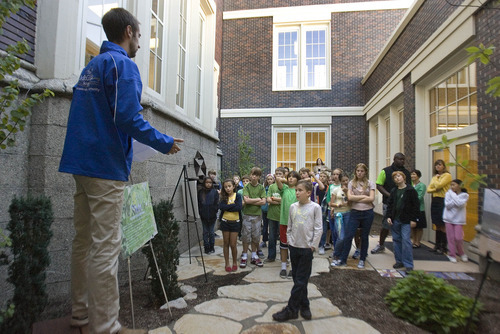 Paul Fraughton | The Salt Lake Tribune
 Teacher Logan Campbell, standing outside the school in a garden courtyard Friday, Oct. 14, talks to McGillis School students about some of the green features included in the building's new remodel. The McGillis School was awarded a  Gold LEED certificate for its green building practices employed in the expansion of the school building.