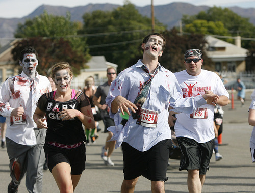 Scott Sommerdorf  |  The Salt Lake Tribune             
Zombie runners during the Night of the Running Dead run at the Utah Fairpark on Saturday. The race featured zombie runners chasing human runners after a two-minute head start for the humans.