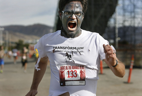 Scott Sommerdorf  |  The Salt Lake Tribune             
One of the undead runners chases human runners during the Night of the Running Dead run at the Utah Fairpark on Saturday.