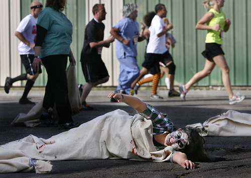 Scott Sommerdorf  |  The Salt Lake Tribune             
Maria Mares played the part of a zombie in a body bag at a CDC station along the roite of the Night of the Running Dead run at the Utah Fairpark on Saturday. The race featured zombie runners chasing human runners.