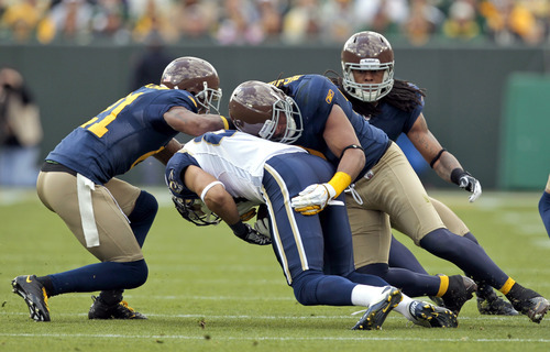 Green Bay Packers cornerback Charles Woodson, left, and Packer's Desmond Bishop tackle St. Louis Rams wide receiver Greg Salas, center, during the first half of an NFL football game on Sunday, Oct. 16, 2011, in Green Bay, Wis. (AP Photo/Mike Roemer)