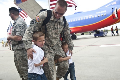 Photo by Chris Detrick | The Salt Lake Tribune 
Staff Sgt. Kevin Lowe hugs his sons Hunter, 6, and Tracer, 4, as he arrives at the Utah Air National Guard Base Saturday May 14, 2011.  About 100 Soldiers of the Utah National Guard's Group Support Company, 19th Special Forces Group (Airborne), returned to Utah from their 12-month deployment to Iraq.
